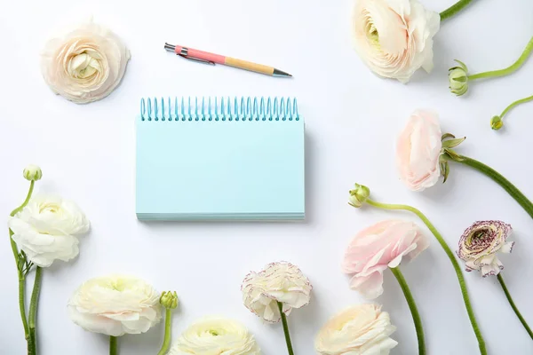 Flat lay composition with spring ranunculus flowers and notebook on white background. Space for text — Stock Photo, Image