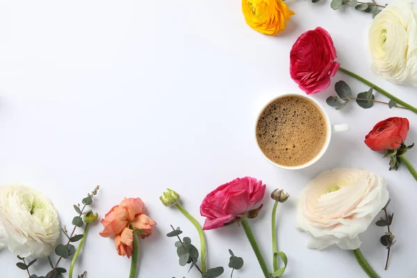 Vlakke lay samenstelling met de lente Ranunculus bloemen en kop van koffie op witte achtergrond. Ruimte voor tekst — Stockfoto