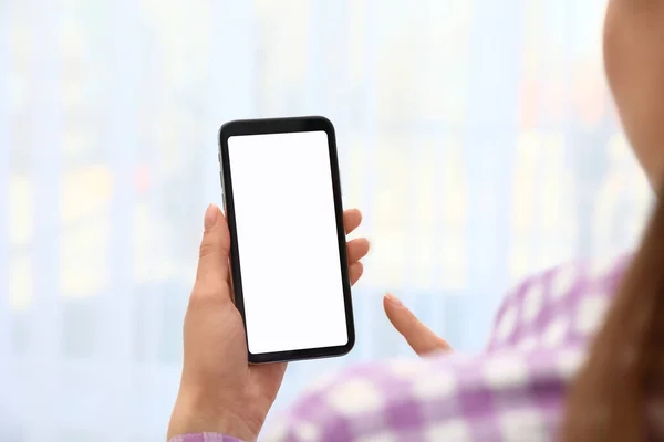 Kobieta trzyma smartfon z pustym ekranem na niewyraźne tło, zbliżenie rąk. Miejsce na tekst — Zdjęcie stockowe