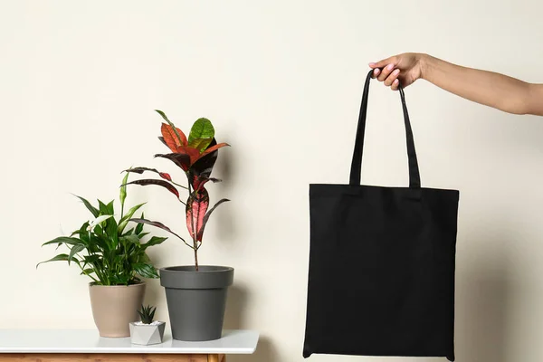 Vrouw met stijlvolle lege Eco tas tegen kleur achtergrond, close-up — Stockfoto