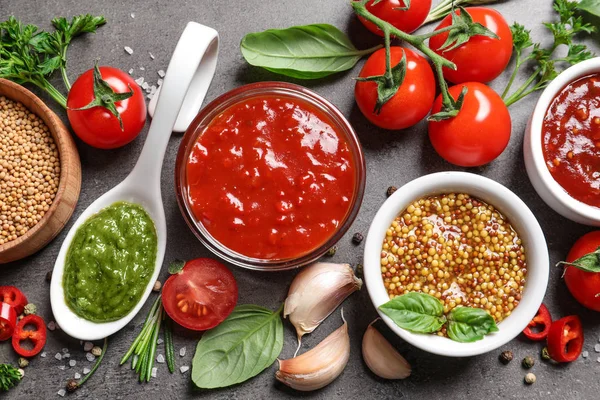 Flat lay composition with different sauces and ingredients on gray background — Stock Photo, Image