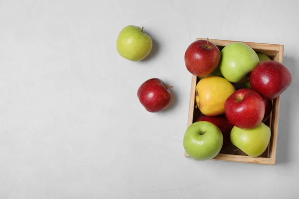 テーブルの上に新鮮なジューシーりんごで満たされた木箱、トップビュー。テキスト用のスペース — ストック写真