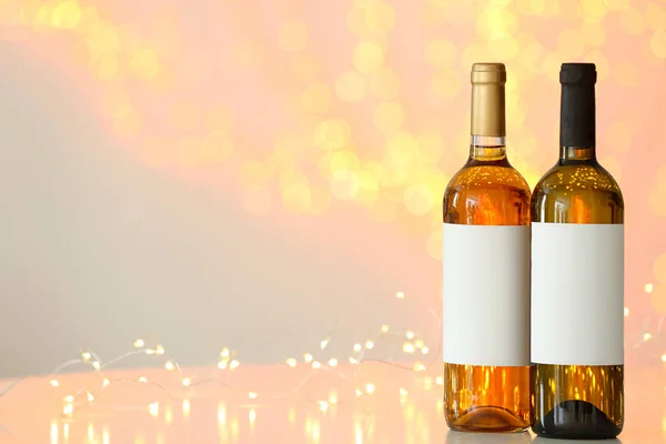 Botellas de vino en la mesa contra las luces borrosas. Espacio para texto —  Fotos de Stock