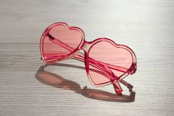 Snygga hjärtformade sol glasögon på trä bakgrund — Stockfoto