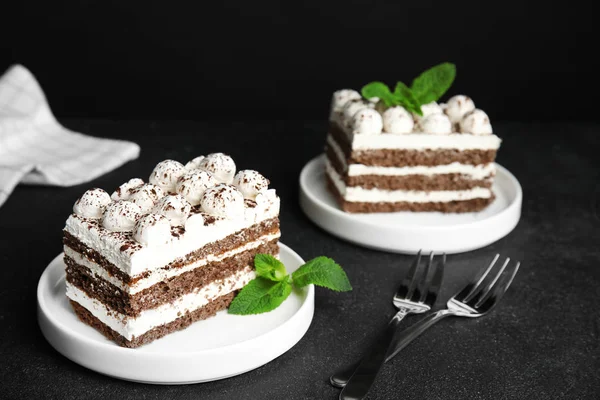 Deliciosos bolos tiramisu com hortelã na mesa — Fotografia de Stock