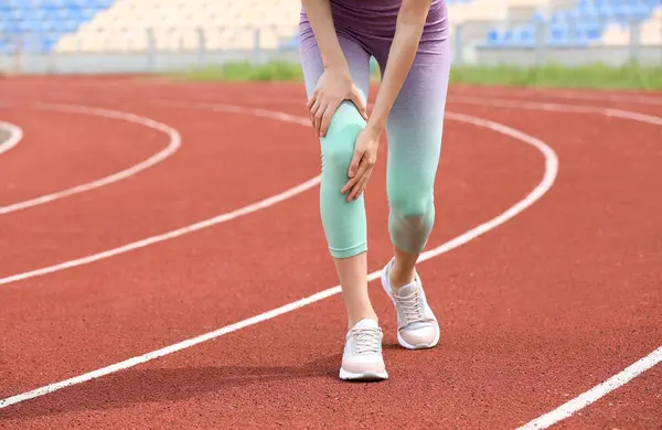 경기장, 근접 촬영에서 무릎 통증으로 고통 받는 스포츠웨어의 여성 — 스톡 사진