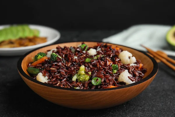 Placa de arroz integral con verduras sobre mesa negra, primer plano — Foto de Stock