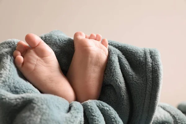 小さな赤ちゃんは、光の背景、クローズアップに対して柔らかい毛布の上に横たわっています。テキスト用のスペース — ストック写真