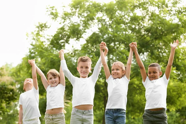 Grupa dzieci trzymanie rąk w parku. Projekt wolontariatu — Zdjęcie stockowe