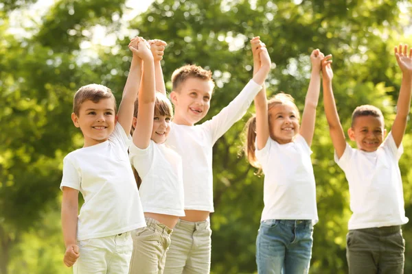 Gruppe von Kindern, die sich im Park die Hände reichen. Ehrenamtliches Projekt — Stockfoto