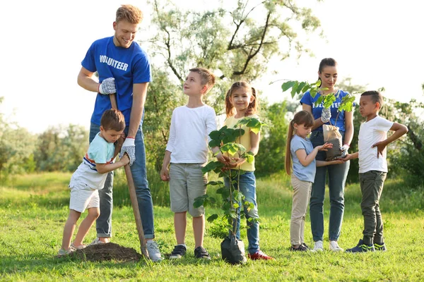 Barn plantera träd med volontärer i parken — Stockfoto