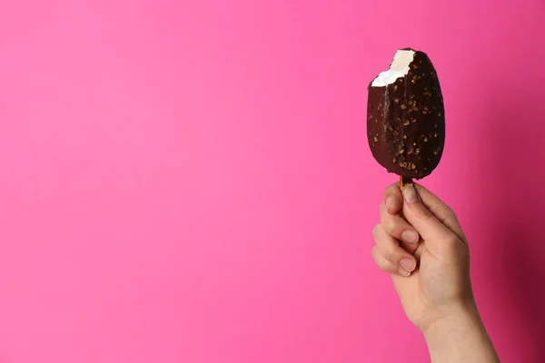 Mulher segurando delicioso sorvete com chocolate contra fundo de cor, espaço para texto — Fotografia de Stock