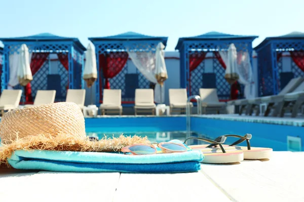 Acessórios de praia no deck de madeira perto da piscina — Fotografia de Stock