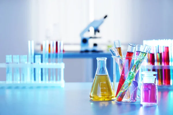 Chemiegläser mit Flüssigkeiten auf dem Tisch im Labor. Raum für Text — Stockfoto