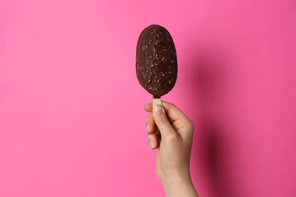 Donna che tiene delizioso gelato con cioccolato sullo sfondo di colore — Foto Stock