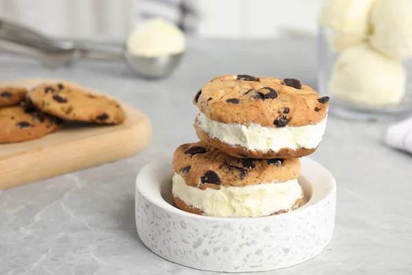 Sweet delicious ice cream cookie sandwiches on table, space for text