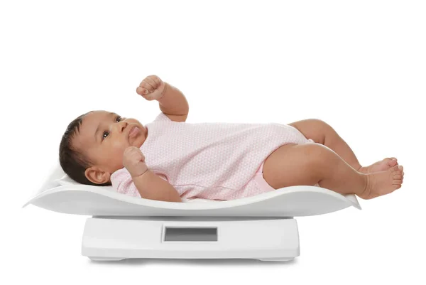 African-American baby lying on scales against white background — Stock Photo, Image