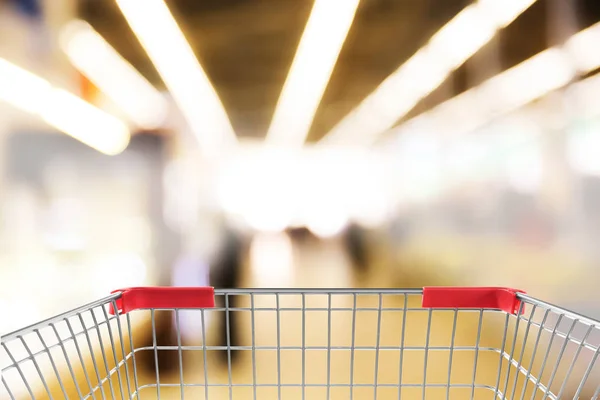 Niewyraźne widok na supermarket i pusty koszyk, zbliżenie — Zdjęcie stockowe