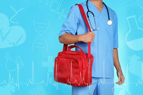 Doctor with first aid kit on color background, closeup. Medical service