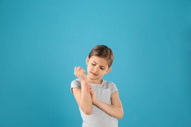 Küçük kız renkli arka planda ön kol kaşıyarak. Alerji belirtileri