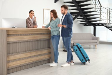 Otelde resepsiyonda müşterilerle çalışan profesyonel resepsiyonist