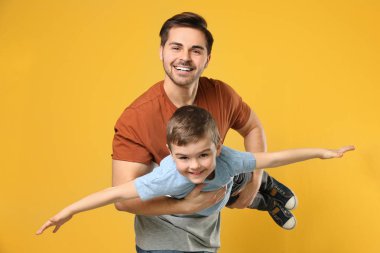 Renkli arka planda oğluyla oynayan baba portresi