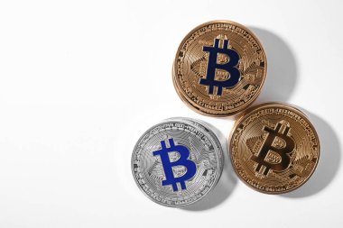 Beyaz arka planda altın ve gümüş bitcoinler, üst görünüm. Dijital para birimi