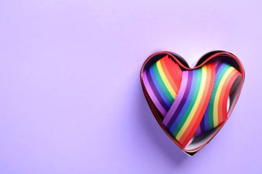 Kalp şeklinde kalıp ve renkli arka plan üzerinde parlak gökkuşağı şerit, metin için boşluk ile üst görünüm. Eşcinsel topluluğunun sembolü