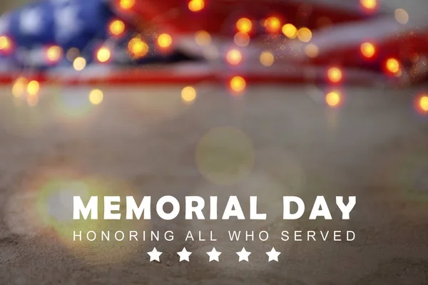 Blurred view of USA flag and garland on table. Memorial day — Stock Photo, Image