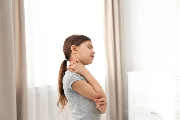 Klein meisje krassen nek binnenshuis. Allergie symptomen — Stockfoto