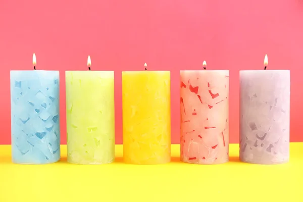 Светлые ароматизированные восковые свечи на цветном фоне — стоковое фото