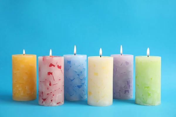 Светлые ароматизированные восковые свечи на цветном фоне — стоковое фото
