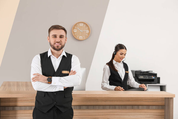 Young receptionists in professional uniform at workplace