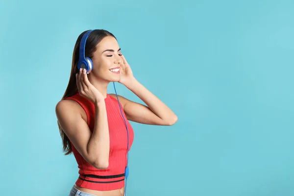 Attraktive junge Frau genießt Musik in Kopfhörern auf farbigem Hintergrund. Raum für Text — Stockfoto