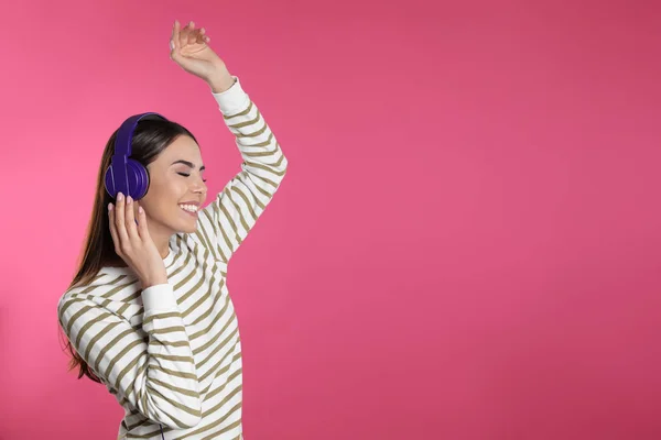 Attraktive junge Frau genießt Musik in Kopfhörern auf farbigem Hintergrund. Raum für Text — Stockfoto