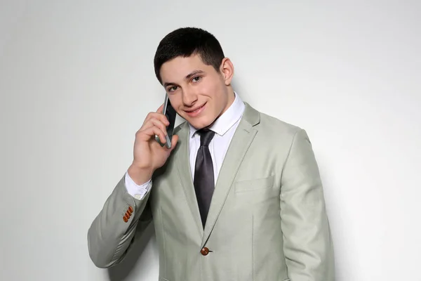 Portret młodego biznesmena rozmawiający na telefon z jasnym tłem — Zdjęcie stockowe