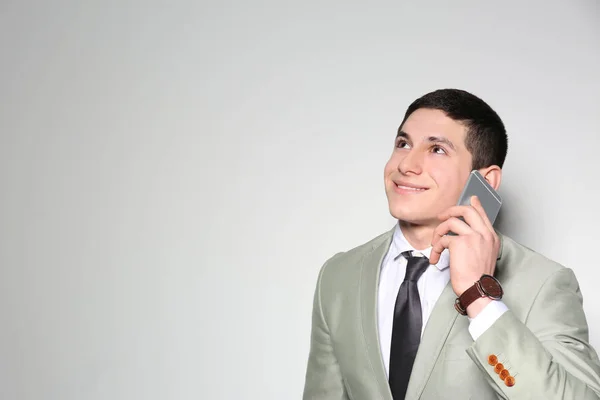 Genç işadamının hafif arka plana karşı telefonda konuştuğu portresi. Metin için alan — Stok fotoğraf