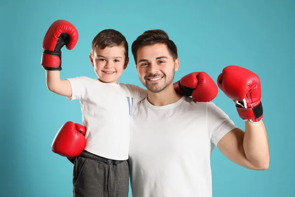 Papá y su hijo con guantes de boxeo sobre fondo de color — Foto de Stock