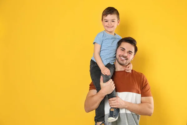 Porträtt av pappa och hans son på färg bakgrund. Utrymme för text — Stockfoto