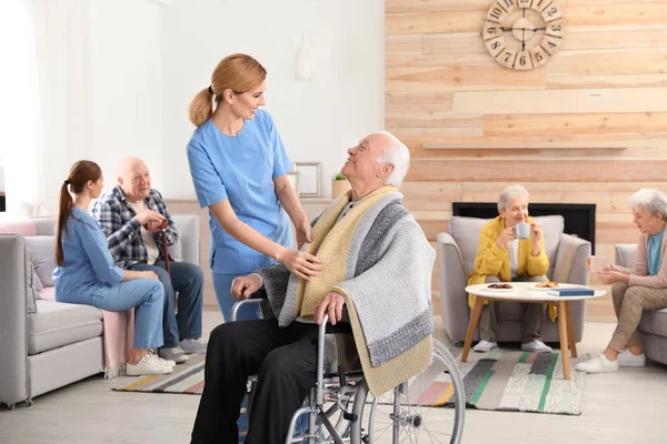Медсестры, помогающие пожилым людям в доме престарелых — стоковое фото
