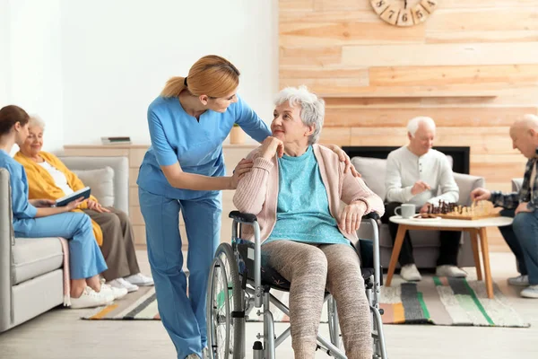 Enfermeras que asisten a personas mayores en un asilo de ancianos — Foto de Stock