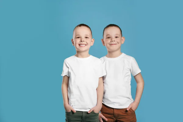 Portrait of cute twin brothers on color background — Stock Photo, Image