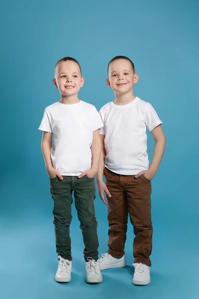 Retrato de comprimento total de irmãos gêmeos bonitos no fundo de cor — Fotografia de Stock