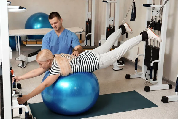 Patiënt trainen onder toezicht van fysiotherapeut in revalidatiecentrum — Stockfoto