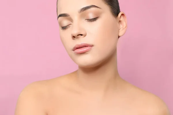 Retrato de mulher jovem com rosto bonito e maquiagem natural no fundo de cor, close-up — Fotografia de Stock