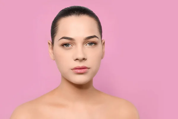 Retrato de mujer joven con rostro hermoso y maquillaje natural sobre fondo de color —  Fotos de Stock