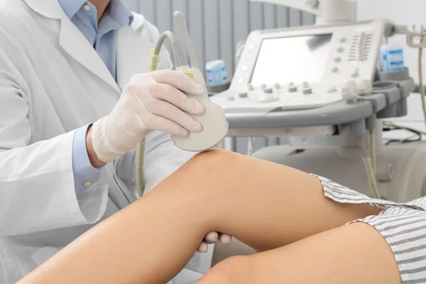 Γιατρός που διεξάγει υπερηχογραφική εξέταση του γόνατος του ασθενούς στην κλινική, κοντινά πλάνα — Φωτογραφία Αρχείου