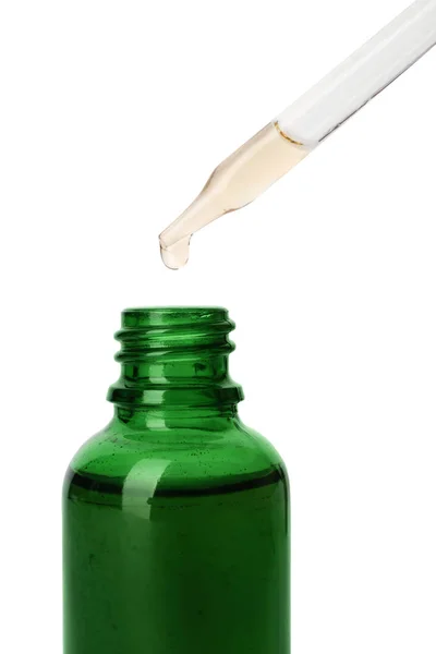 在白色背景上从移液器滴入玻璃瓶的精油 — 图库照片