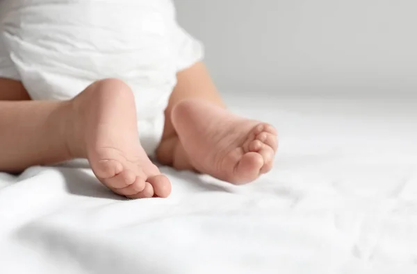 Cute little baby crawling on white bed sheet, closeup. Space for text — Stock Photo, Image