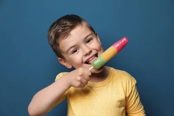 Bedårande liten pojke med läcker glass mot färg bakgrund — Stockfoto